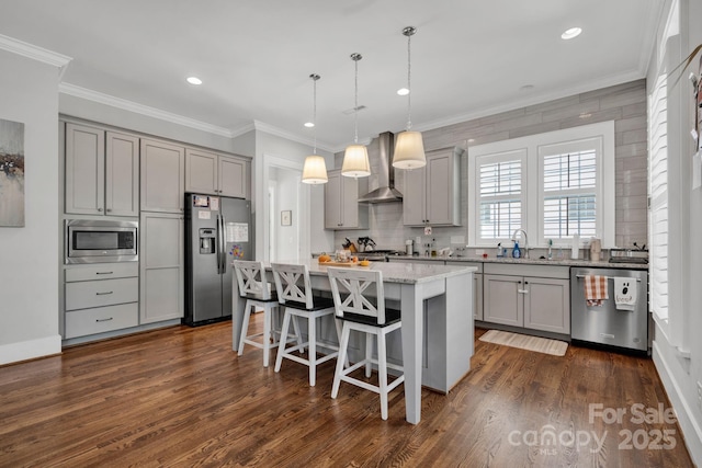 kitchen featuring a kitchen island, appliances with stainless steel finishes, pendant lighting, gray cabinetry, and wall chimney exhaust hood