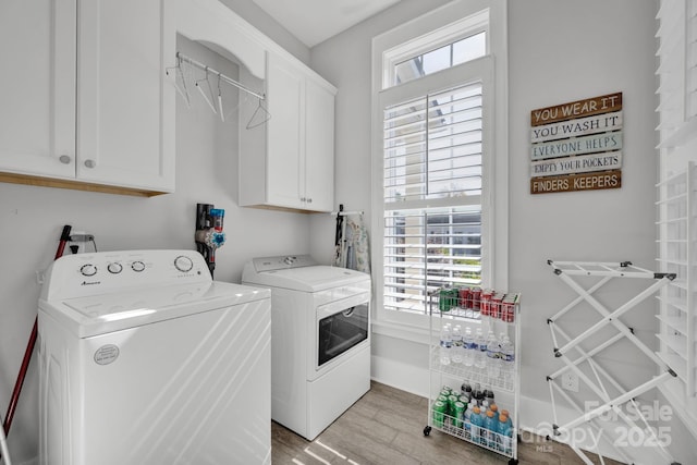 laundry room with independent washer and dryer, cabinets, and light hardwood / wood-style flooring