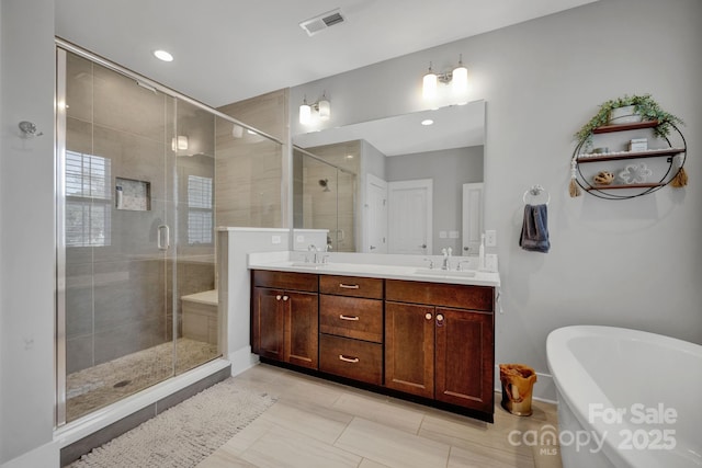 bathroom featuring vanity and independent shower and bath