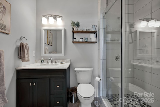 bathroom with a shower with door, vanity, and toilet