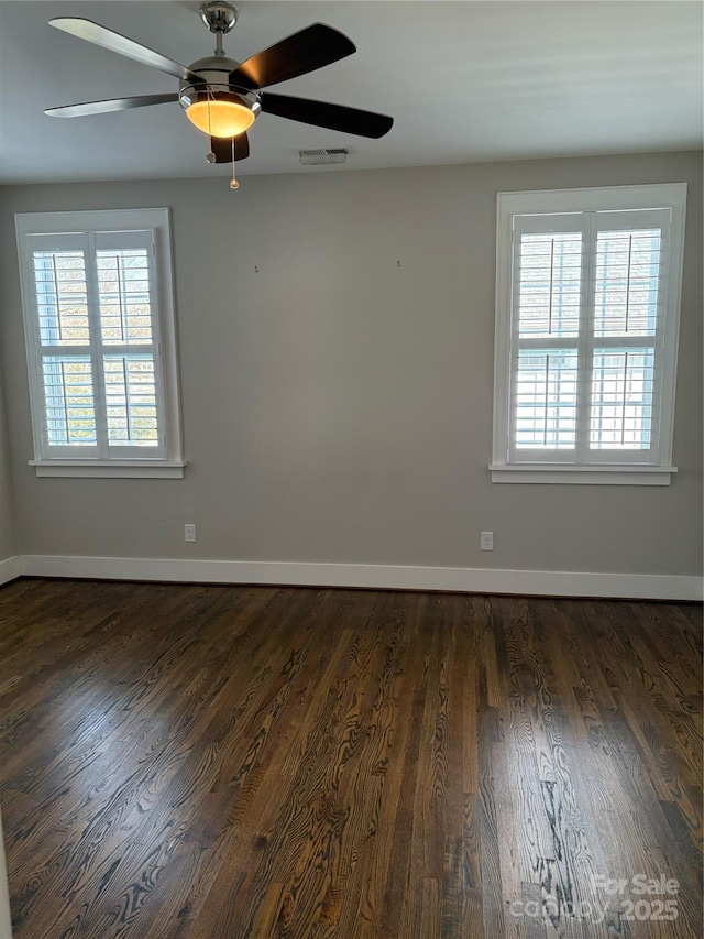 unfurnished room with dark wood-type flooring, ceiling fan, and a healthy amount of sunlight