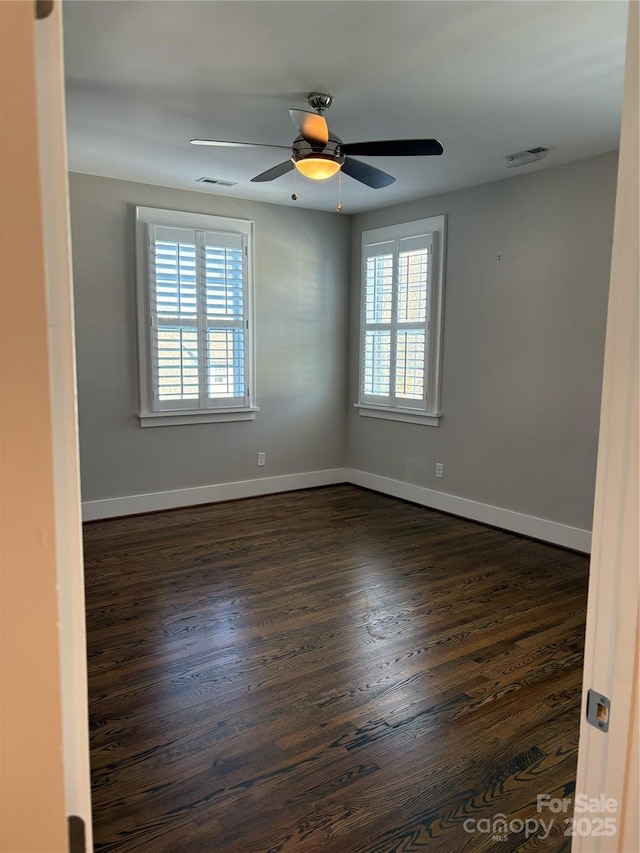 empty room featuring ceiling fan and dark hardwood / wood-style flooring