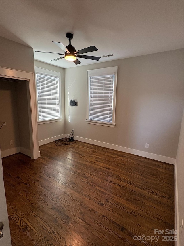 unfurnished bedroom featuring ceiling fan and dark hardwood / wood-style floors