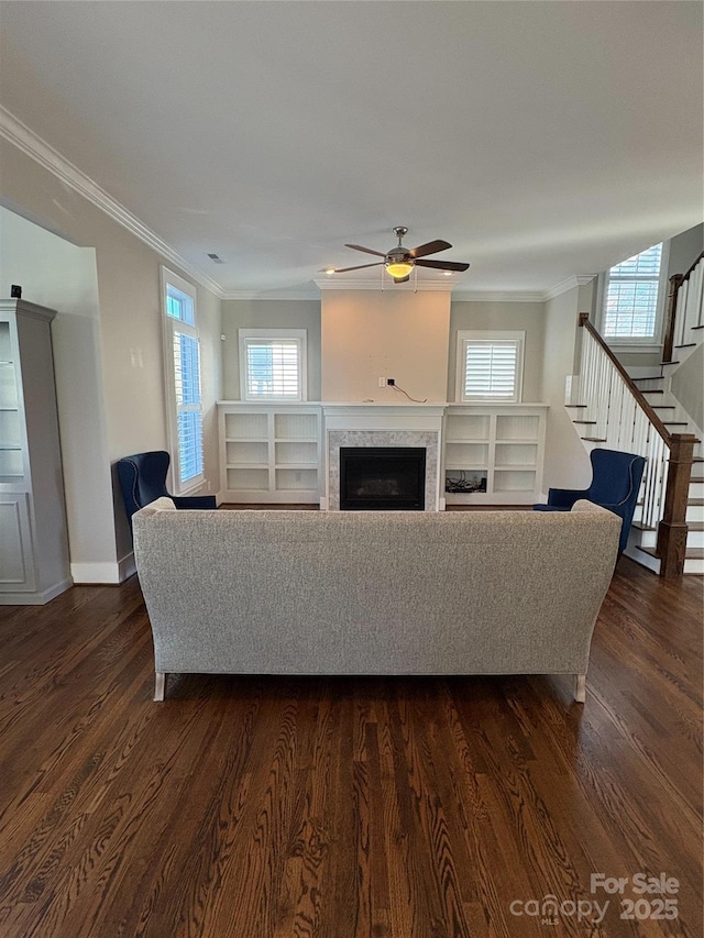 living room featuring crown molding, dark wood-type flooring, and a wealth of natural light