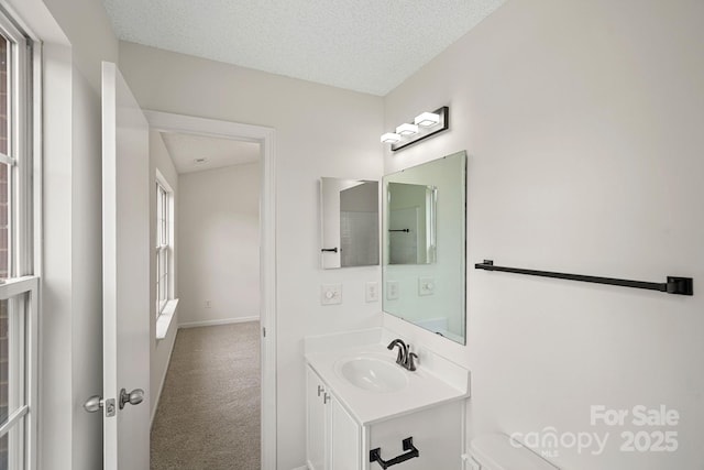 bathroom with a textured ceiling, toilet, and vanity