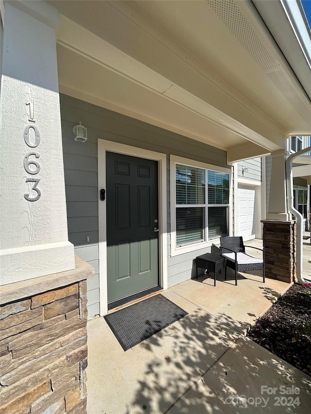 entrance to property with covered porch and a garage