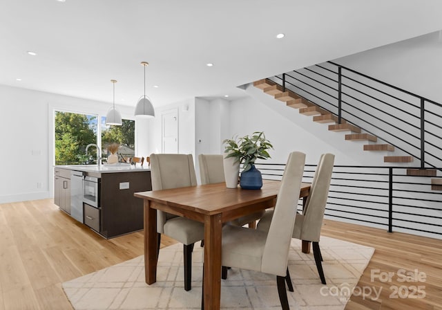 dining room with sink and light hardwood / wood-style flooring