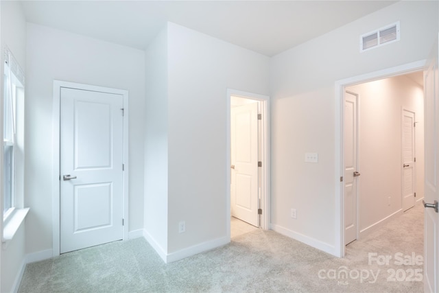 unfurnished bedroom featuring light carpet