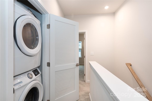 clothes washing area featuring stacked washer and clothes dryer and light colored carpet