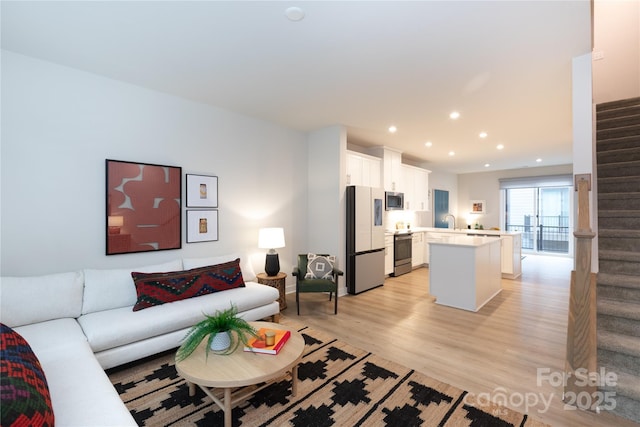 living room featuring sink and light hardwood / wood-style floors