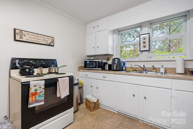 720A-C Harris Ave NW, Valdese, NC 28690 - kitchen with light countertops, range with electric cooktop, a sink, stainless steel microwave, and white cabinets