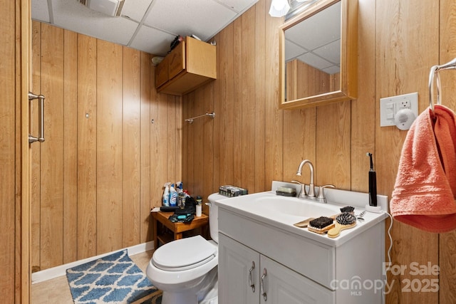 720A-C Harris Ave NW, Valdese, NC 28690 - bathroom featuring a drop ceiling, toilet, vanity, and wood walls