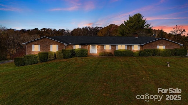 ranch-style home featuring a lawn