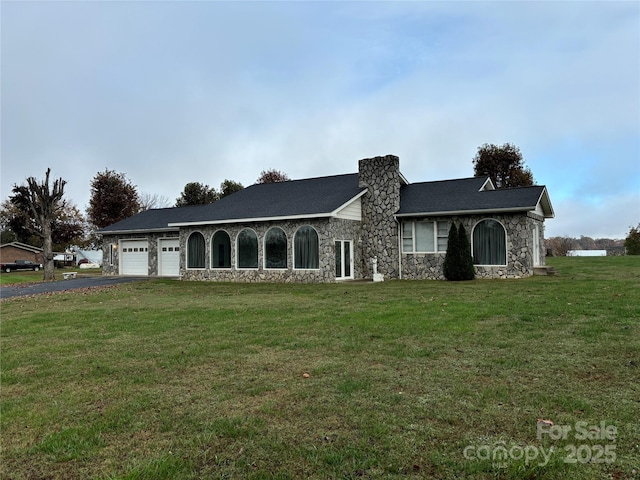 ranch-style house featuring a garage and a front lawn