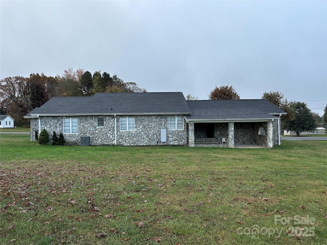 rear view of house featuring a lawn and cooling unit