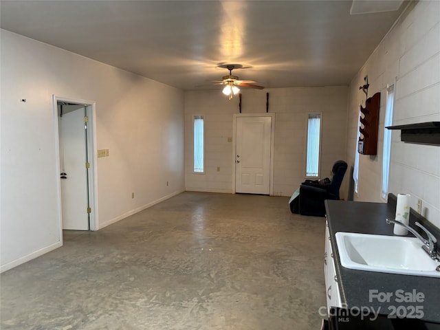 kitchen featuring white cabinetry, ceiling fan, sink, and concrete floors