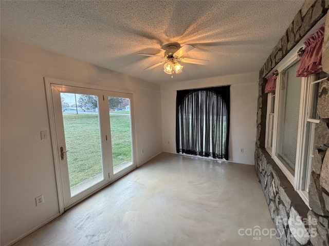 spare room with ceiling fan and concrete flooring