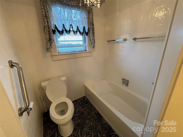 bathroom with toilet, a tub, and a chandelier