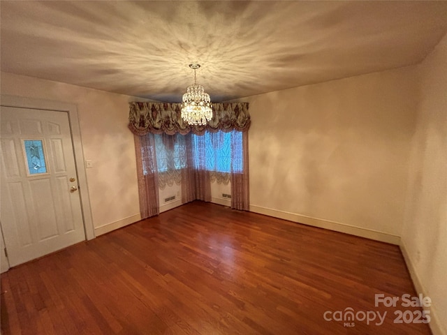 unfurnished dining area featuring hardwood / wood-style flooring and a chandelier