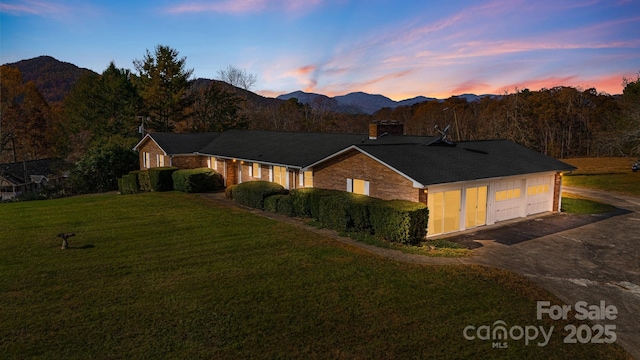 view of front of home featuring a mountain view, a yard, and a garage