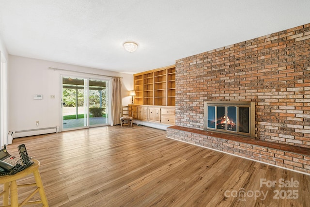 unfurnished living room featuring a baseboard radiator, hardwood / wood-style floors, a fireplace, and built in shelves