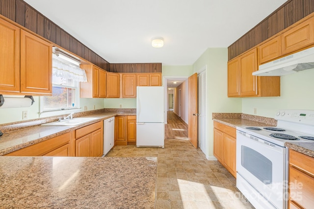 kitchen with light stone counters, sink, and white appliances