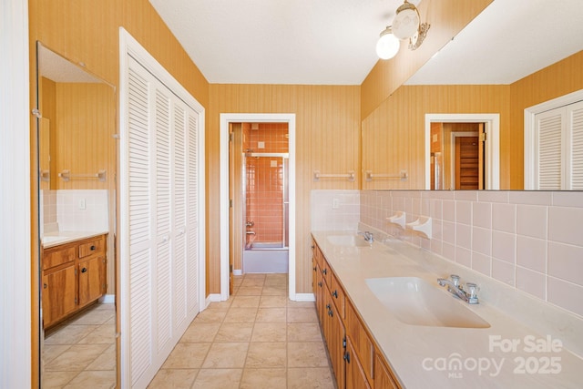 bathroom with vanity, tile patterned floors, backsplash, and shower / bath combination with glass door