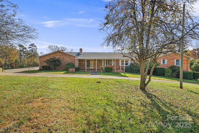 ranch-style house with a porch and a front lawn