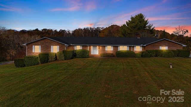 ranch-style home featuring a lawn