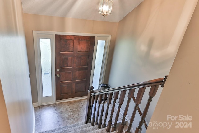 tiled foyer featuring a notable chandelier and a textured ceiling