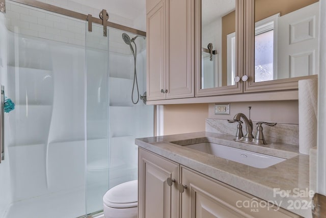 bathroom featuring vanity, toilet, and an enclosed shower