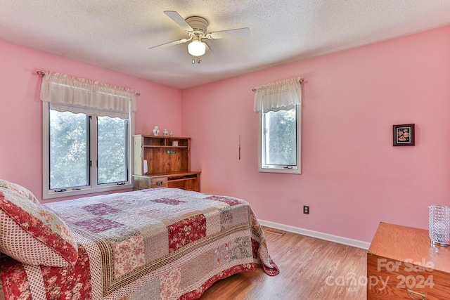 bedroom featuring a textured ceiling, wood-type flooring, and ceiling fan