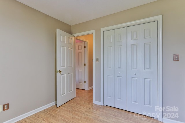 unfurnished bedroom featuring light hardwood / wood-style flooring and a closet