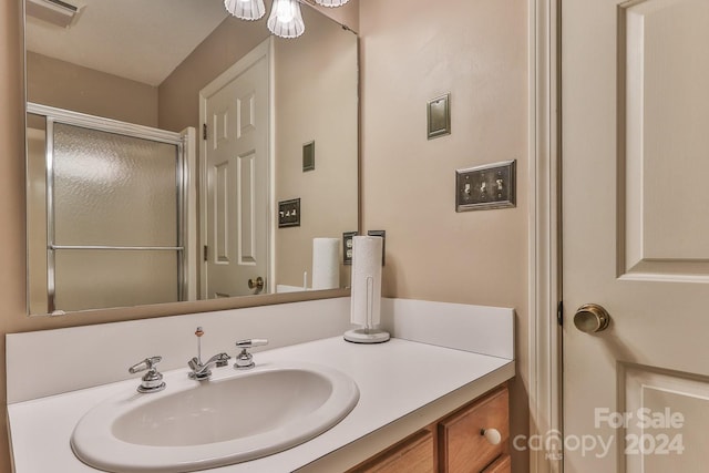 bathroom featuring vanity and a shower with shower door