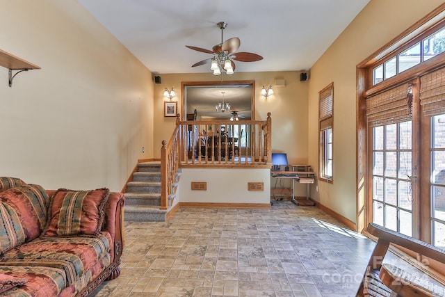 living room with ceiling fan with notable chandelier