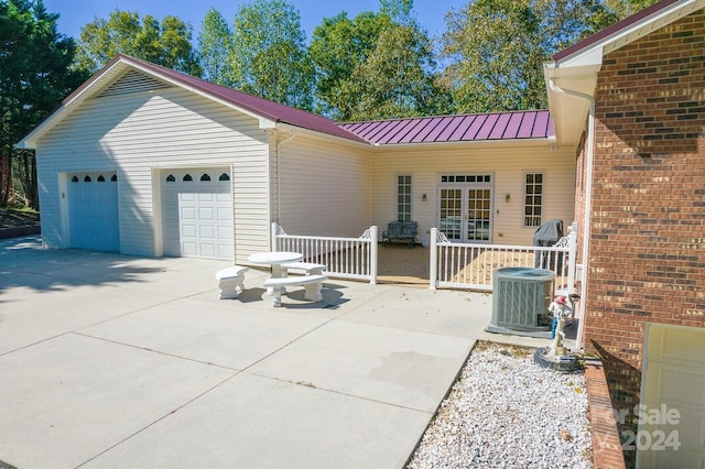 view of front facade featuring central air condition unit and a garage