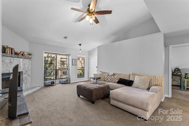 living room with light carpet, ceiling fan, a premium fireplace, and lofted ceiling