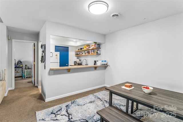 bar featuring white fridge, dark carpet, and sink