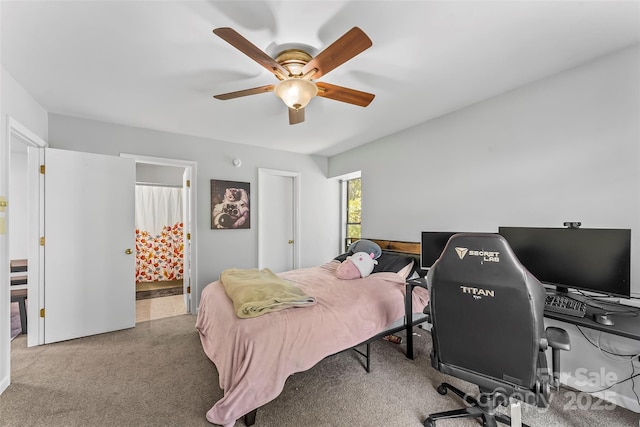 carpeted bedroom featuring ceiling fan and ensuite bath