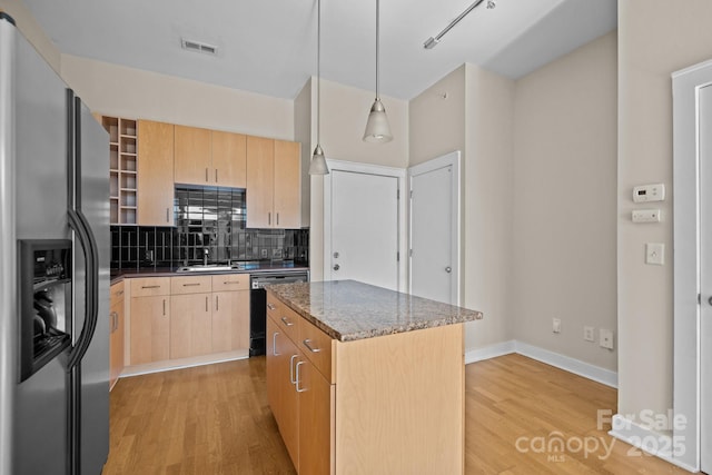 kitchen featuring dishwasher, a center island, stainless steel refrigerator with ice dispenser, light brown cabinetry, and decorative light fixtures