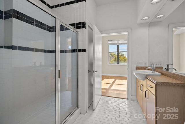 bathroom with vanity, a shower with shower door, and tile patterned floors