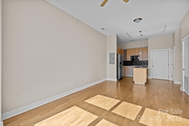 unfurnished living room featuring ceiling fan and light hardwood / wood-style flooring