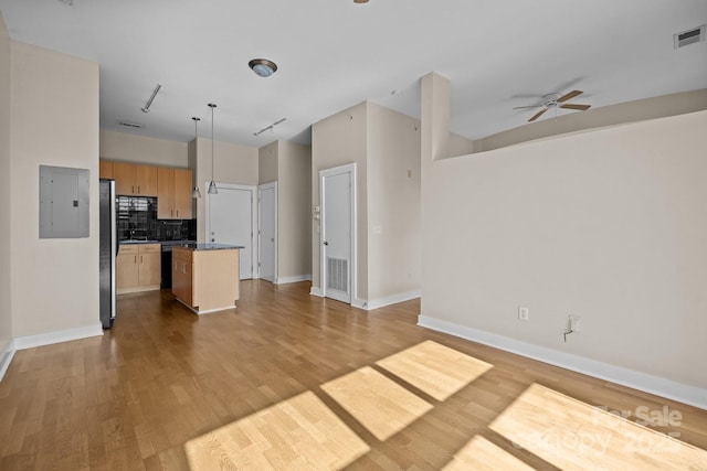 kitchen featuring tasteful backsplash, hanging light fixtures, a center island, electric panel, and ceiling fan