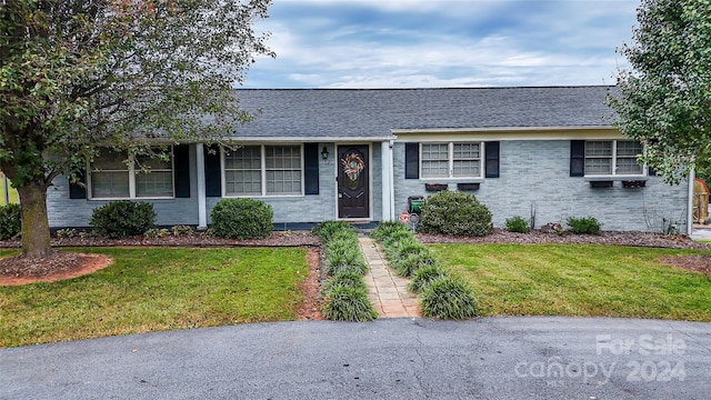 single story home with a front lawn