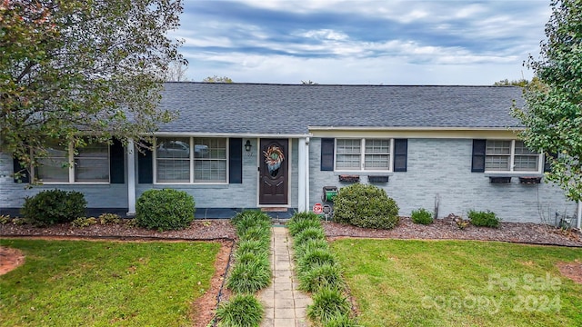 ranch-style home featuring a front lawn