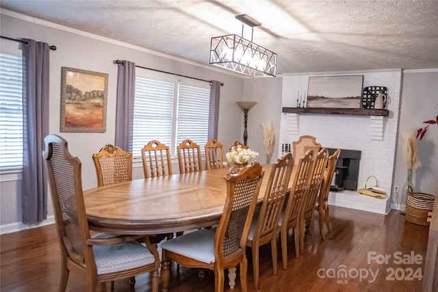 dining area featuring ornamental molding, a fireplace, a textured ceiling, and dark hardwood / wood-style flooring