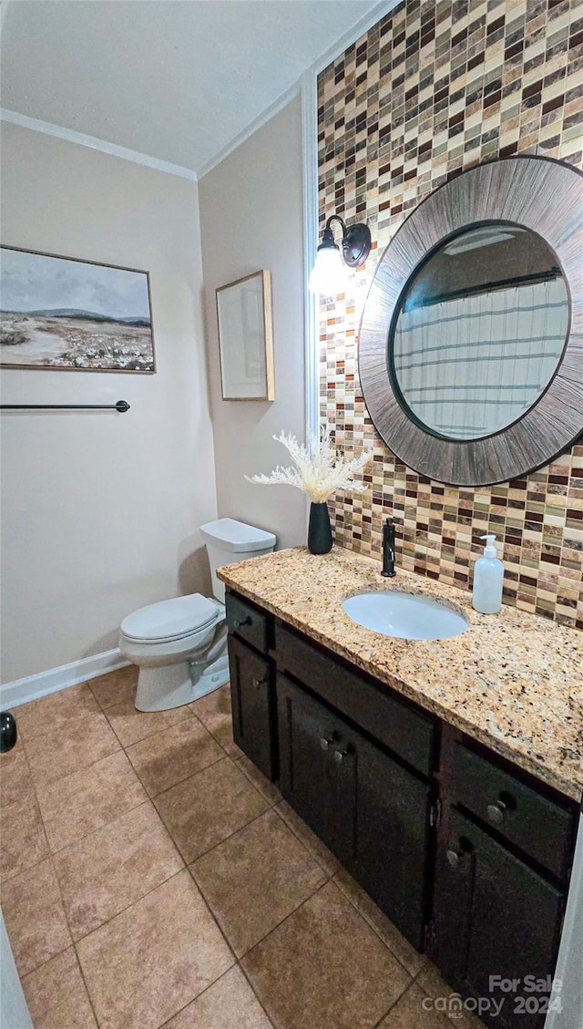 bathroom featuring vanity, decorative backsplash, toilet, and ornamental molding