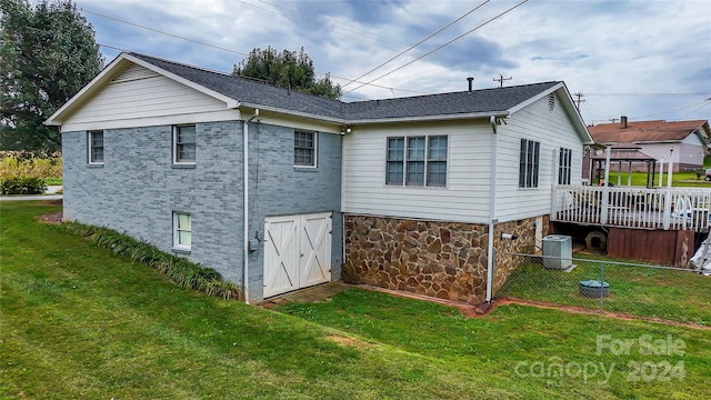 back of house with a wooden deck, a yard, and central AC unit