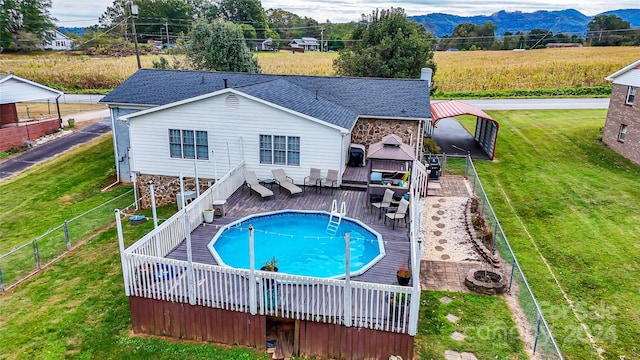 view of swimming pool featuring a yard and a deck with mountain view