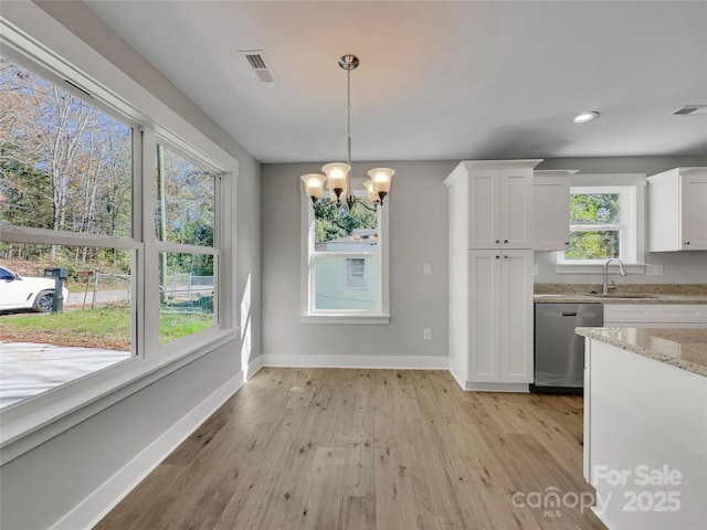 unfurnished dining area featuring a chandelier, light wood-type flooring, and sink